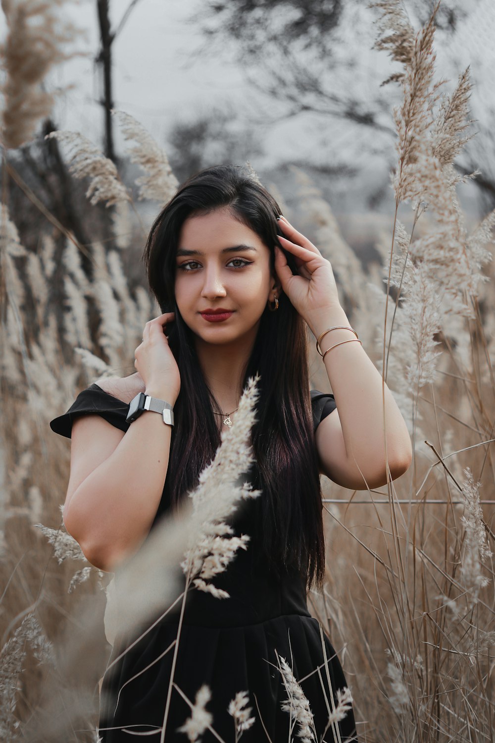 a woman standing in a field of tall grass