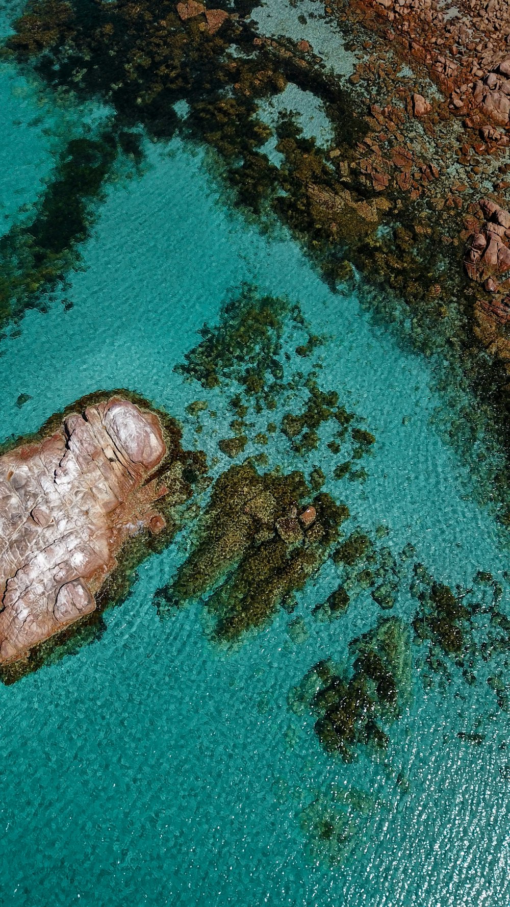 an aerial view of a body of water surrounded by rocks