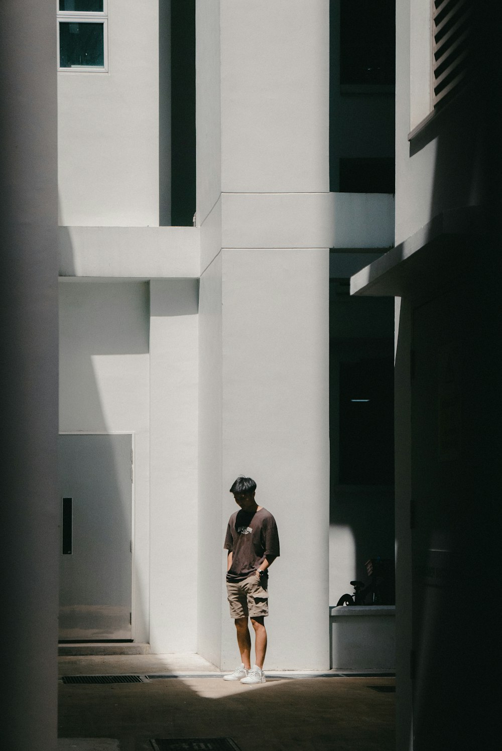 Un hombre parado frente a un edificio alto y blanco