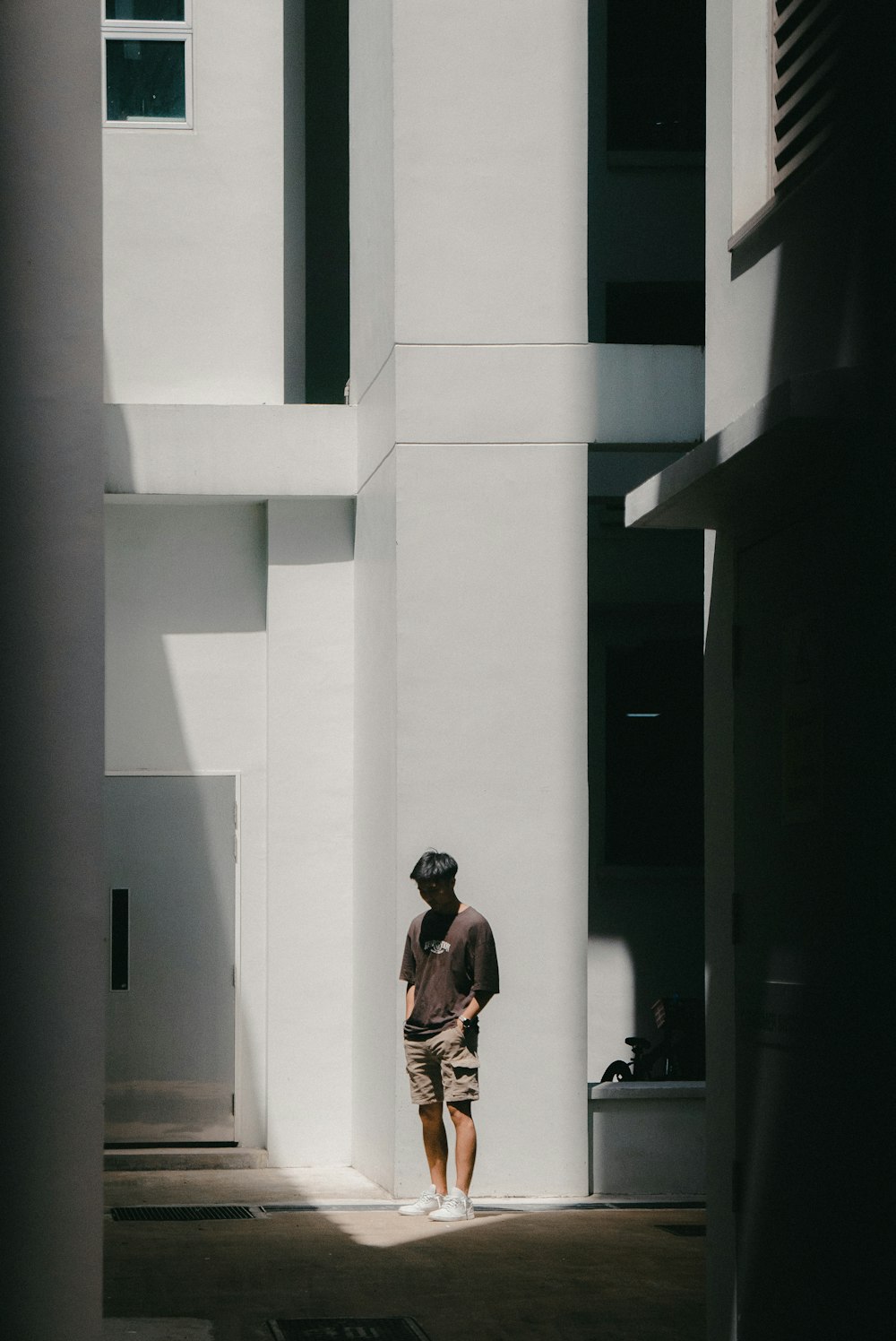 a man standing in front of a tall white building