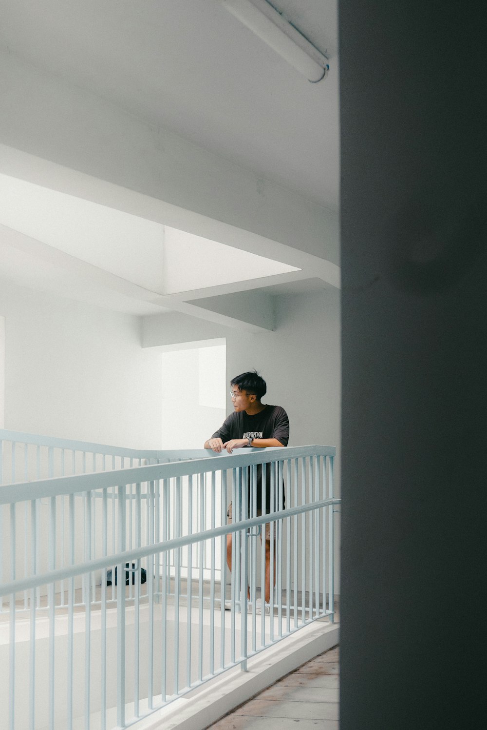 a man standing on a balcony next to a white railing