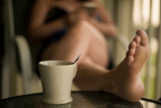 a person sitting at a table with a cup of coffee