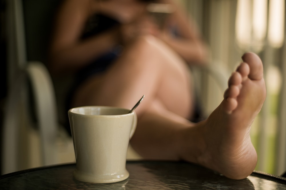 a person sitting at a table with a cup of coffee