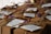 Brown cardboard gift boxes are tied with twine, decorated with small dried flowers and tags containing handwritten messages. The overall presentation is rustic and elegant.