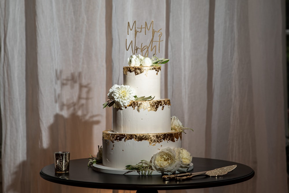 a three tiered cake with white flowers on a table