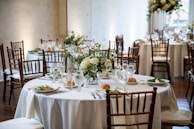 Round tables dressed with crisp linens and neatly arranged dishes for a private celebration.