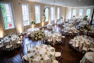 Elegant banquet hall set up for a wedding reception with warm lighting and floral decorations