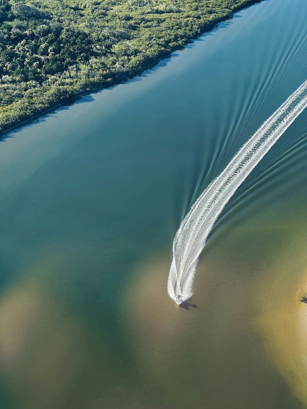 an aerial view of a boat in a body of water