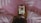 A person is holding a smartphone with several social media applications displayed on the screen. The person is lying on a patterned, pink blanket. The smartphone screen shows apps including Snapchat, Instagram, Facebook Messenger, WhatsApp, and two others.