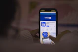 A smartphone displaying the LinkedIn app with notifications and connections.