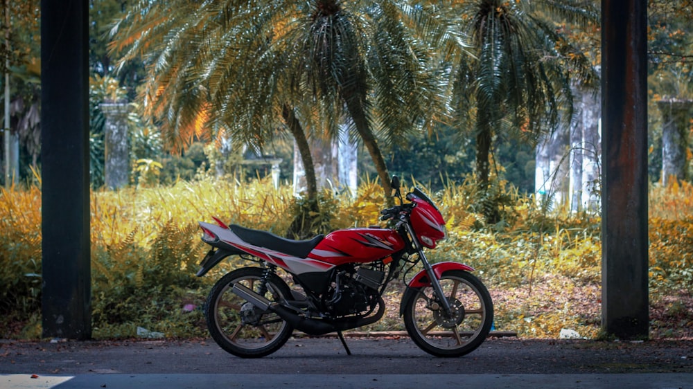 a red and white motorcycle parked on the side of a road
