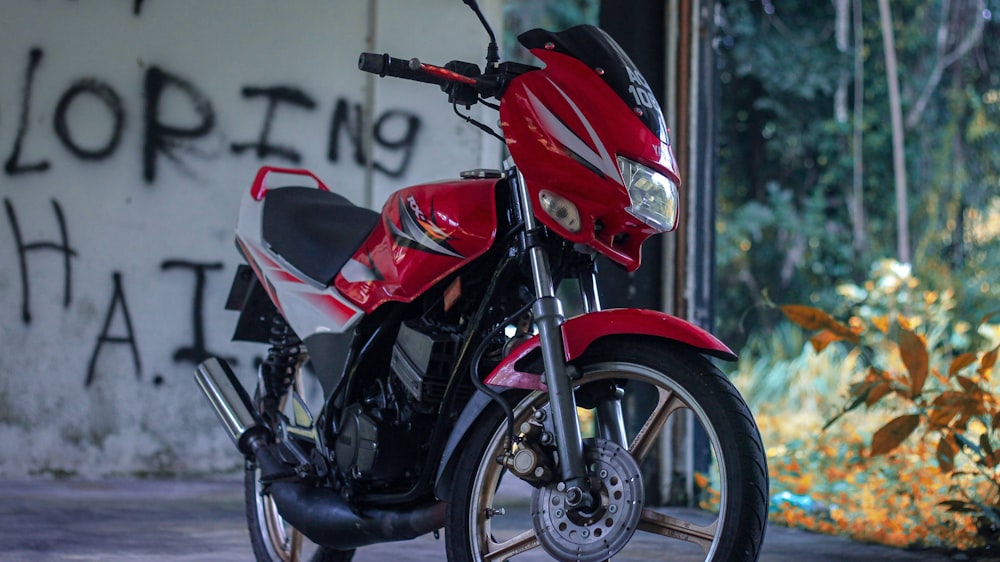 a red motorcycle parked in front of a building