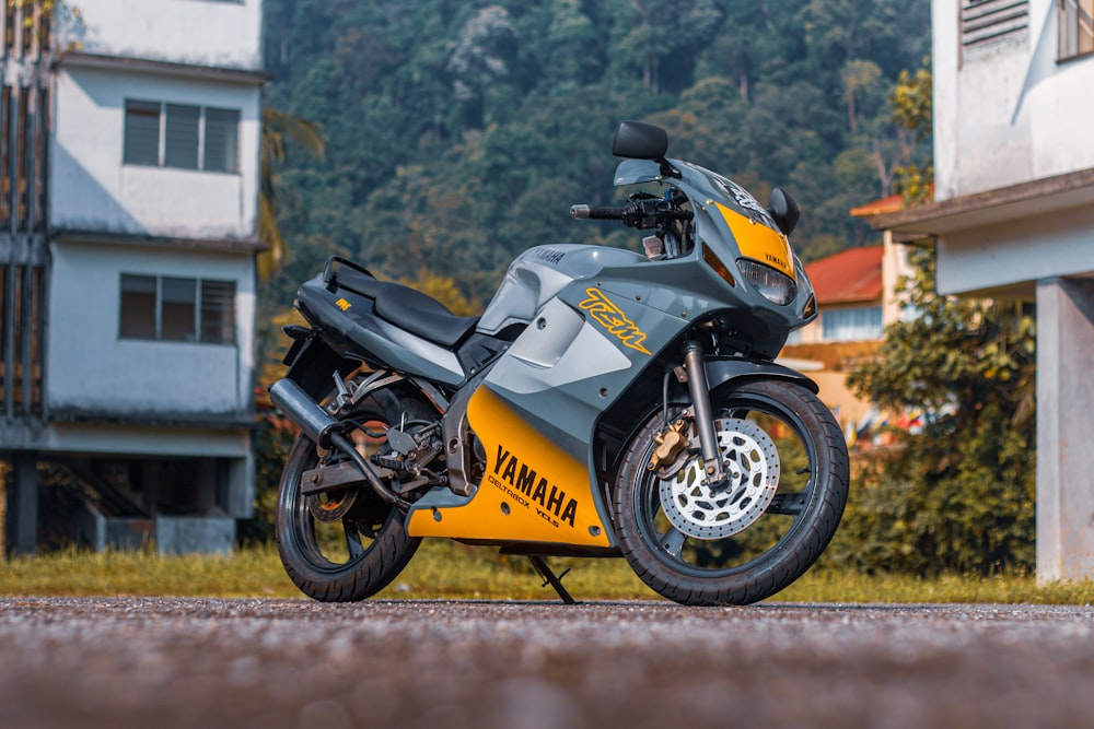 a yellow and gray motorcycle parked in front of a building