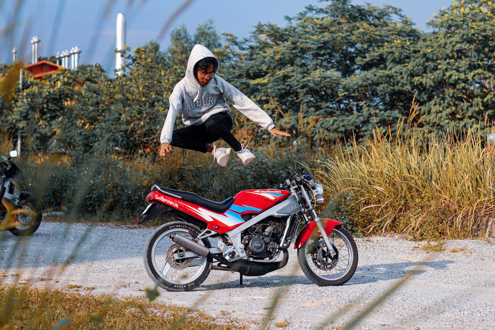 a person jumping in the air over a motorcycle