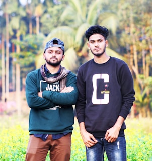two men standing next to each other in a field