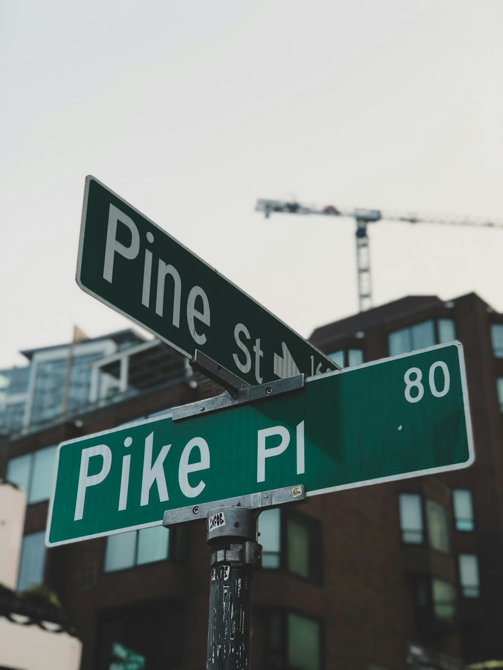 two green street signs sitting on top of a metal pole