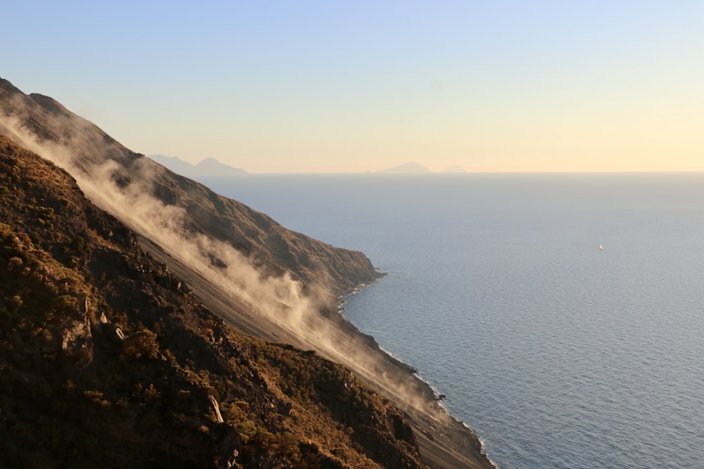 steam rises from the water near a cliff