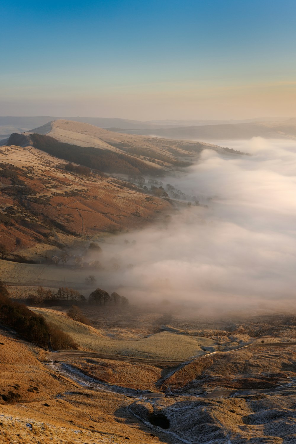 a view of a valley covered in low lying clouds