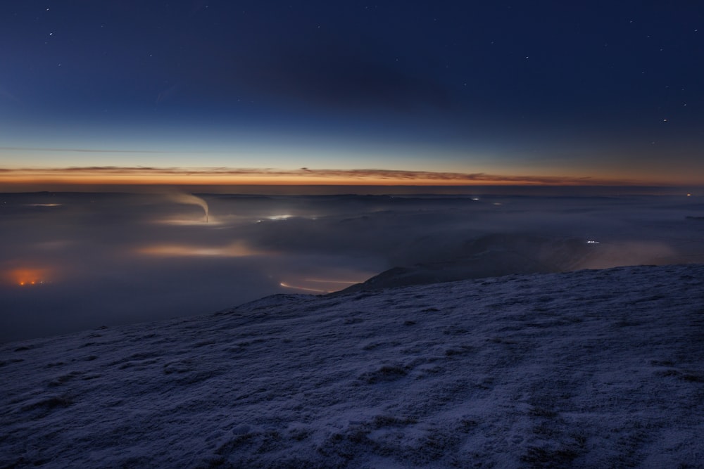 a view of a foggy mountain at night