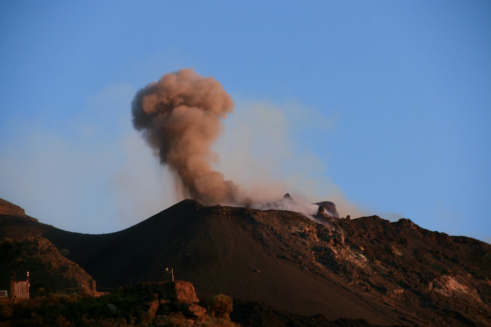 smoke billows from the top of a mountain