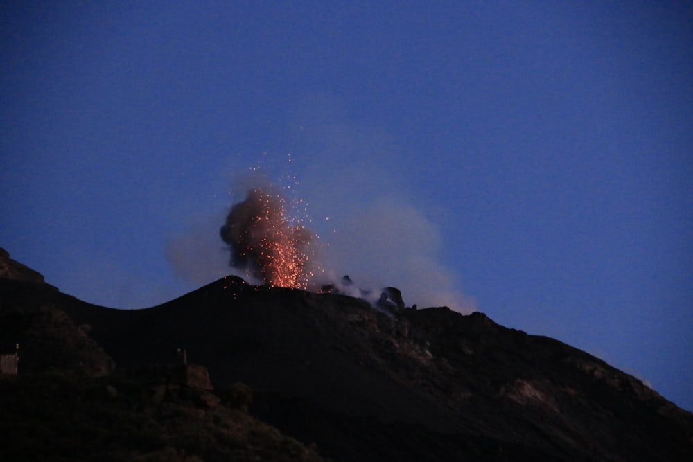 a volcano erupts smoke as it erupts into the night sky