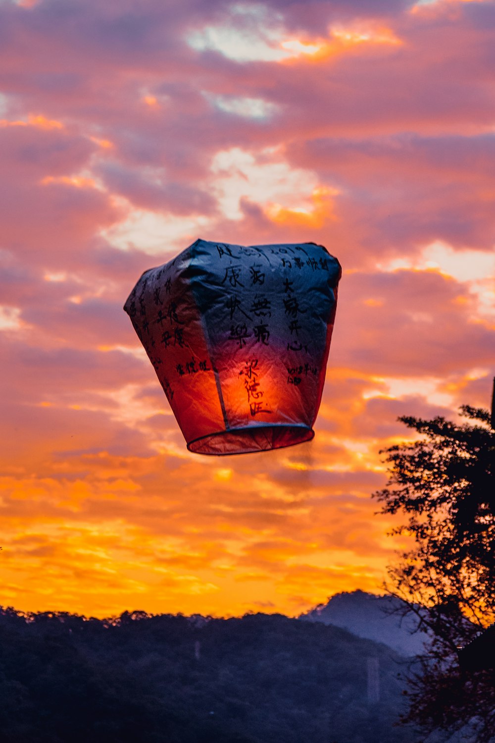 a chinese lantern flying in the sky at sunset