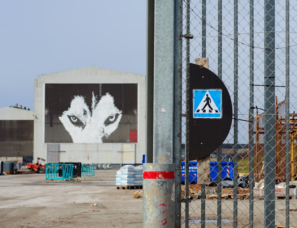 a picture of a wolf on a building behind a fence