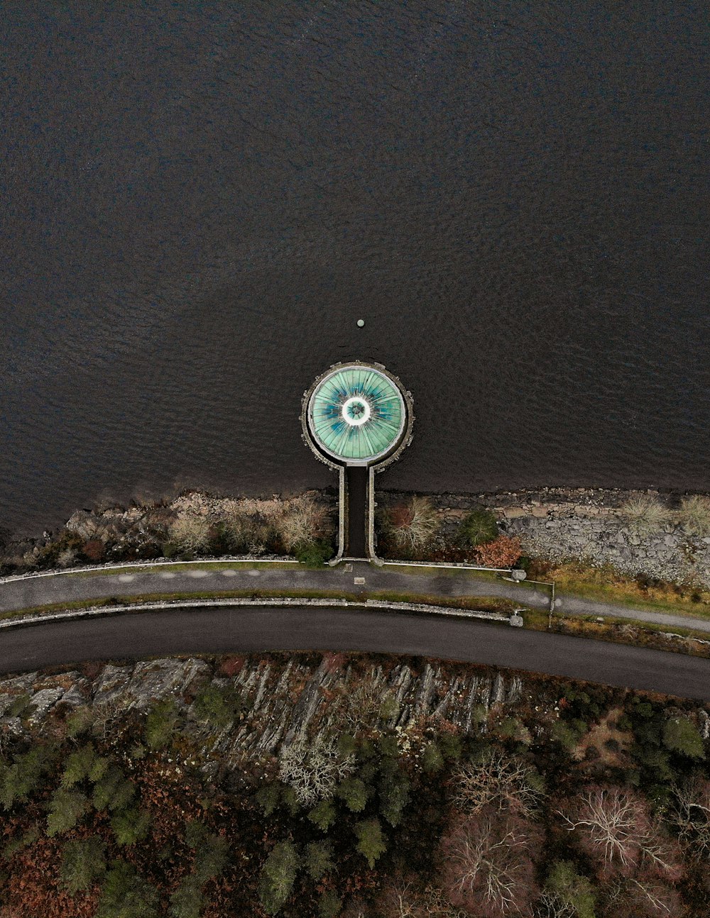 an aerial view of a clock tower near a body of water