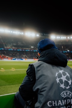a man sitting on a bench in front of a soccer field