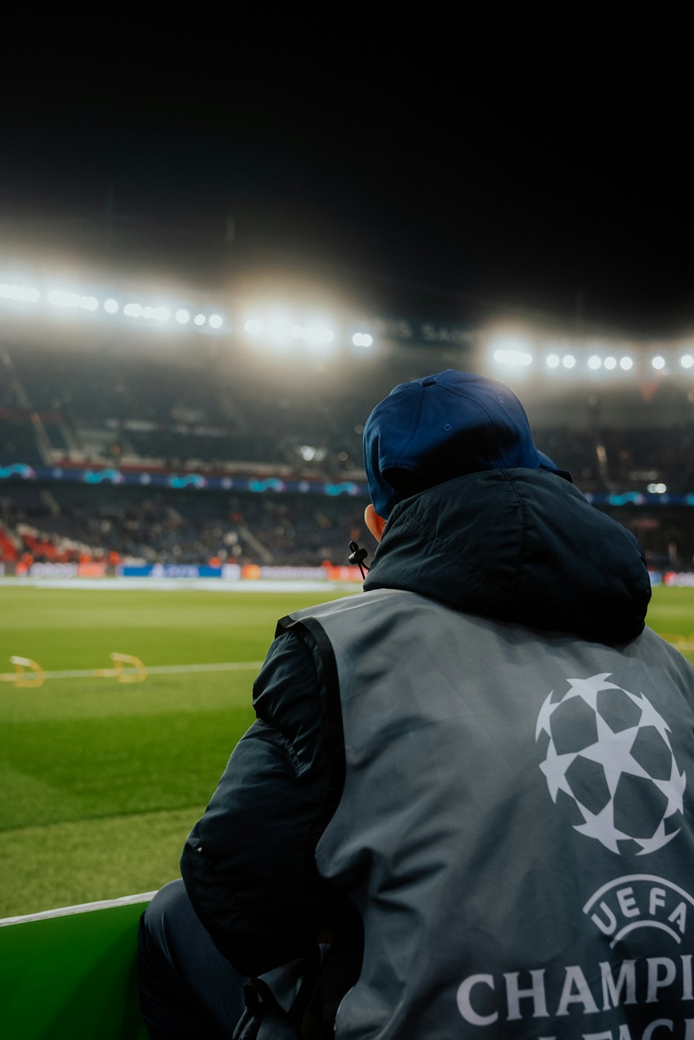 a man sitting on a bench in front of a soccer field