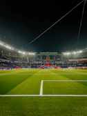 a soccer field at night with the lights on