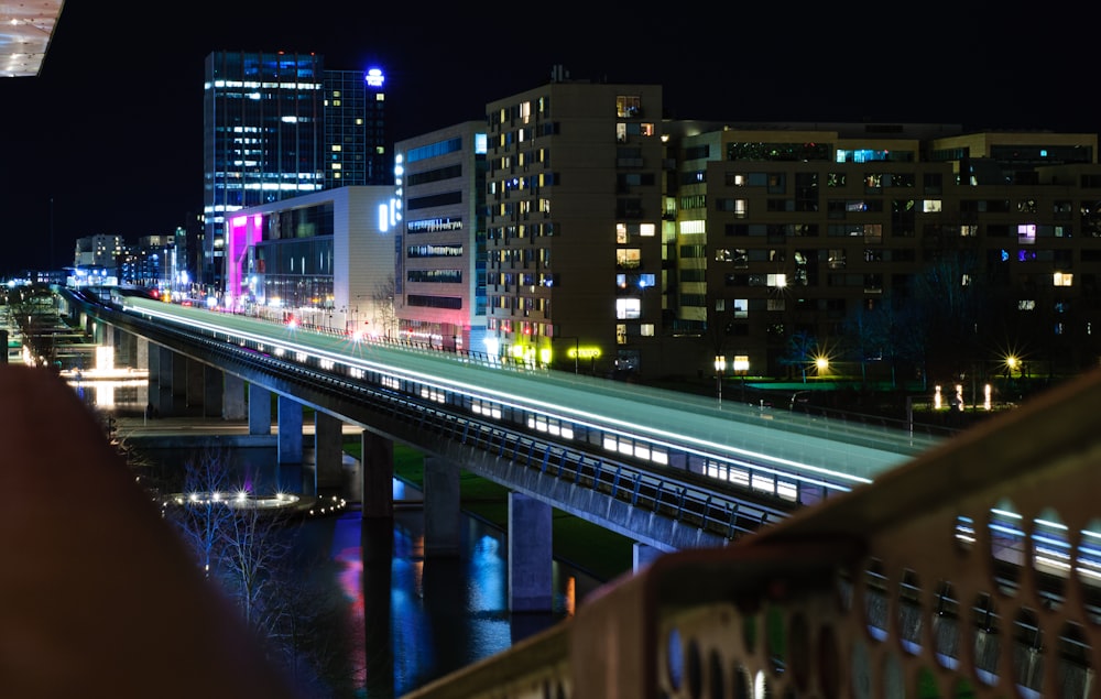 Una vista de una ciudad por la noche desde un puente
