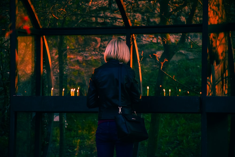 a woman standing on a bridge with candles in the background