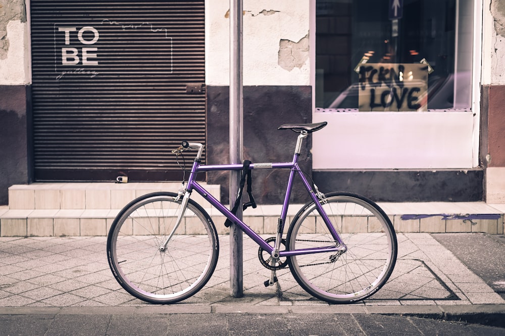 a purple bike parked in front of a store