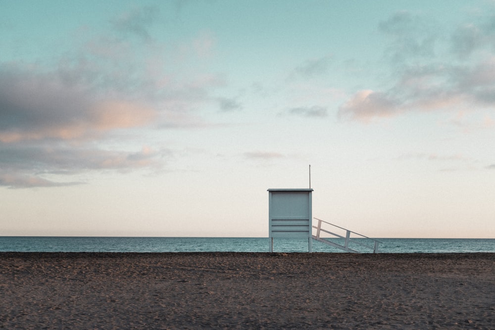 a lifeguard tower sitting on the beach next to the ocean
