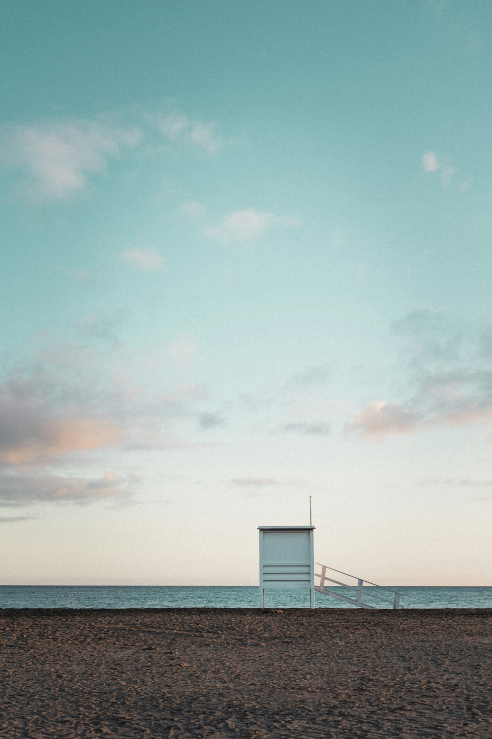 a beach with a lifeguard chair and a life guard tower