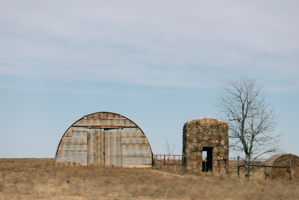 an old barn and silo in a field