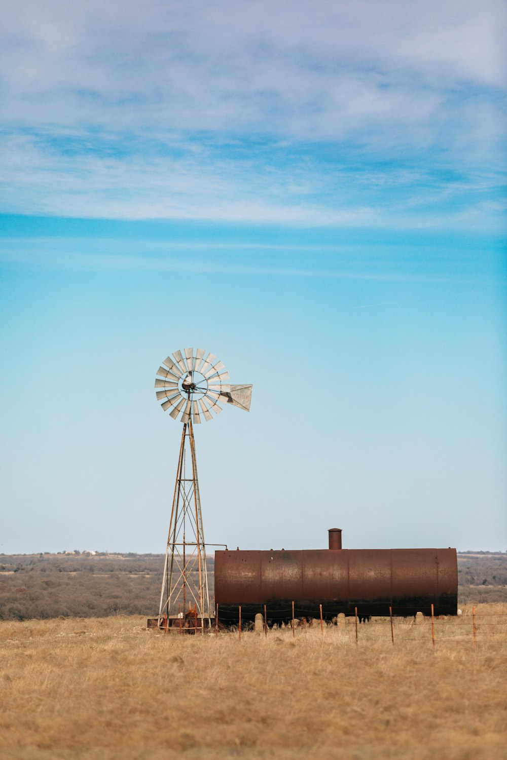 a windmill and a tank in a field