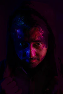 Professional portrait of a mystic surrounded by ritualistic elements in red, black, and beige tones.