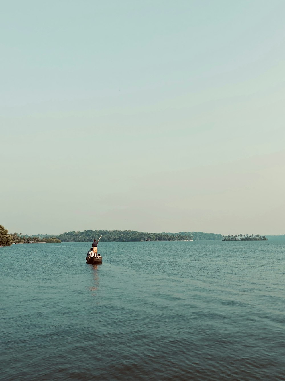 a person in a small boat on a large body of water