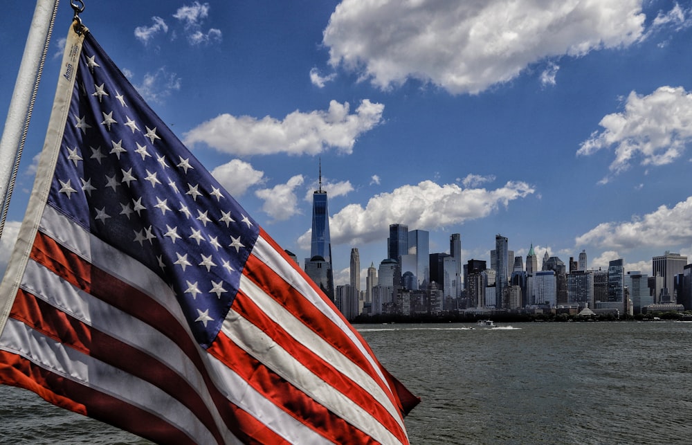 an american flag flying in front of a city skyline