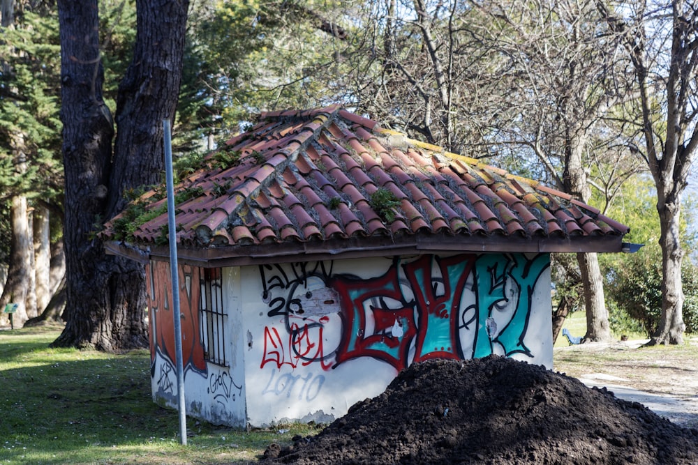 a pile of dirt next to a building with graffiti on it