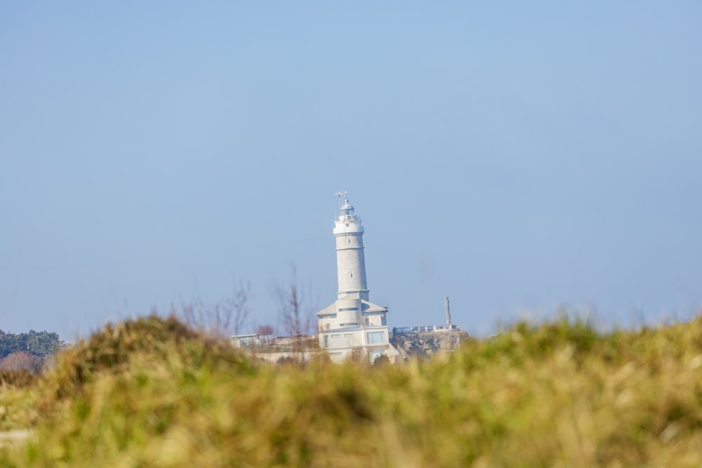 un phare au sommet d’une colline avec un fond de ciel