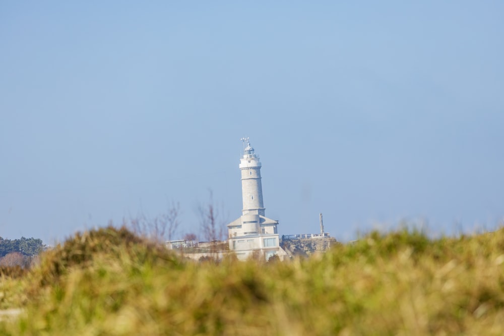 a lighthouse on top of a hill with a sky background