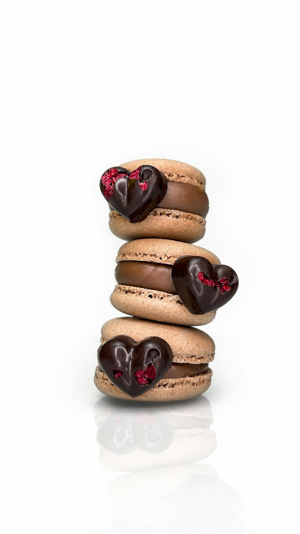 a stack of macaroons with chocolate hearts on them