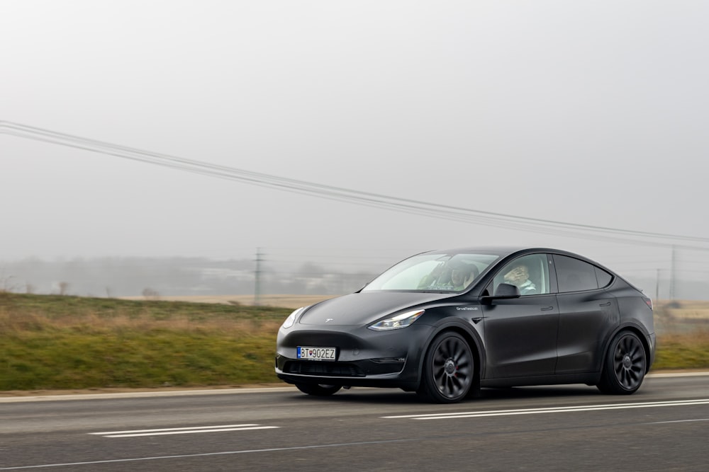 Ein schwarzes Tesla-Auto fährt die Straße entlang