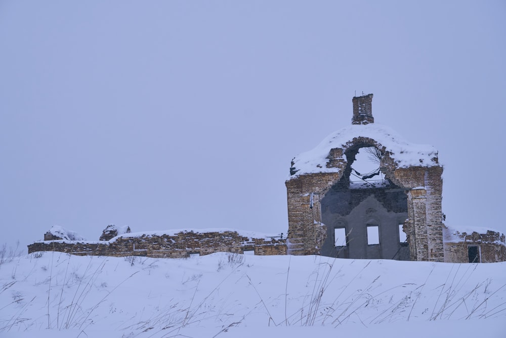 Un vecchio edificio con una campana sopra di esso nella neve