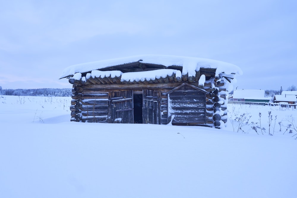 una capanna di tronchi con neve sul tetto