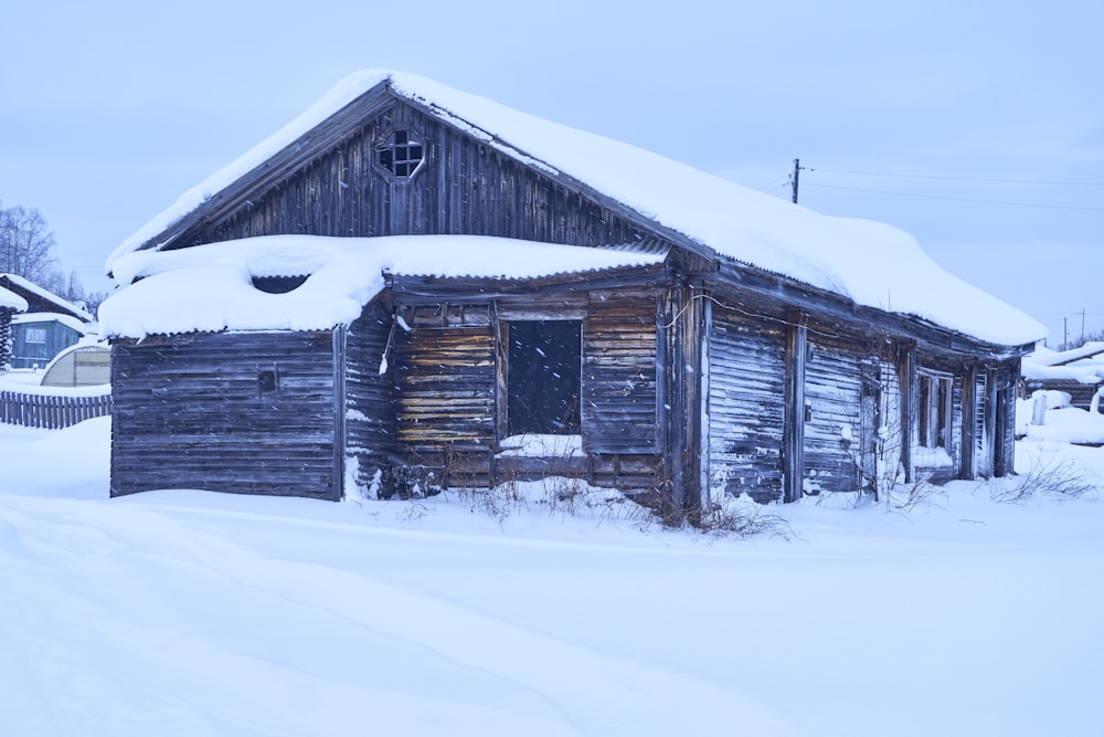 Una vecchia capanna di tronchi è coperta di neve