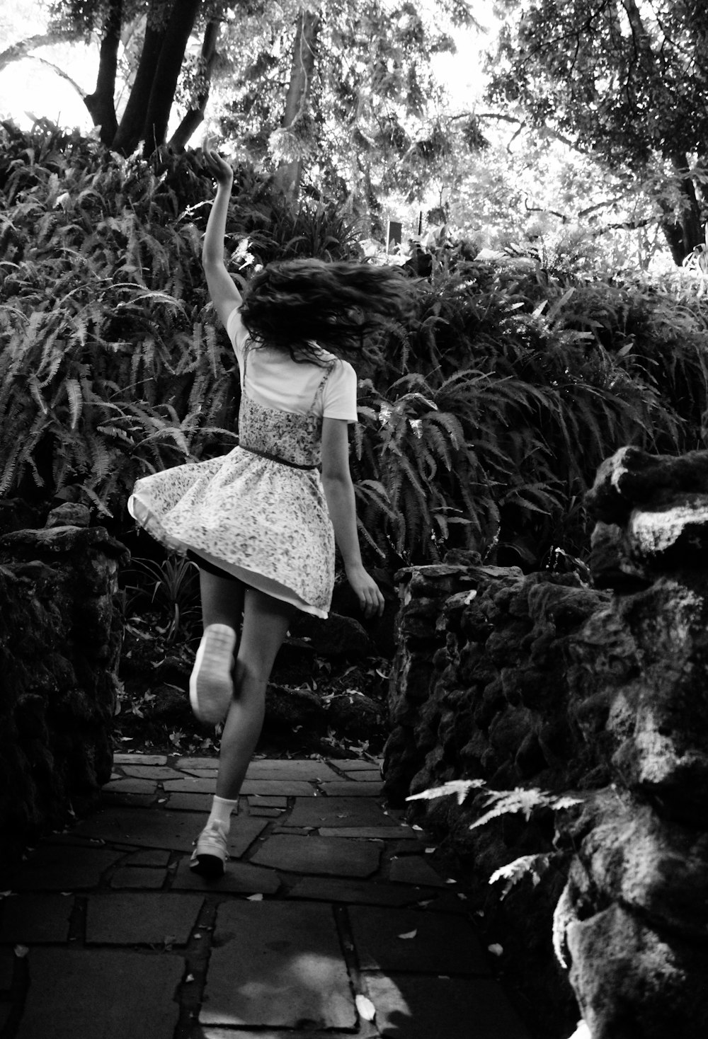 a girl in a dress is running down a path